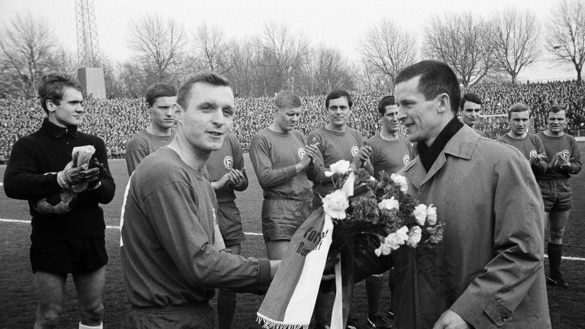 Eishockey auf dem Rasen? Hier gratuliert der Kapitän von Fortuna Düsseldorf, Reinhold Straus (links), dem DEG-Kapitän Peter Gregory (rechts) zum Gewinn der Deutschen Eishockeymeisterschaft 1966/67.