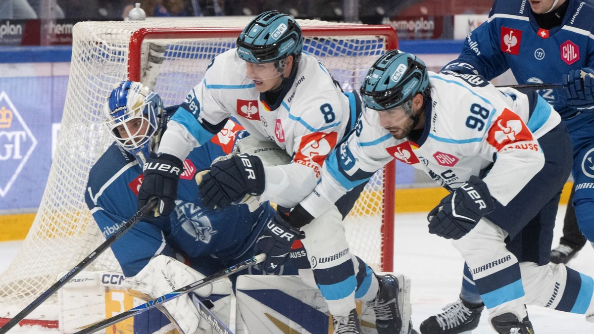 Die Ingolstädter Philipp Krauss (Mitte) und Peter Abbandonato im Duell mit Zugs Torhüter Tim Wolf.