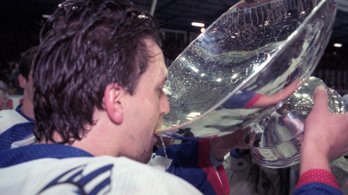 Christian Lukes nimmt einen Schluck aus dem Pott: Die Adler Mannheim wurden in der Saison 1996/97 Deutscher Meister.