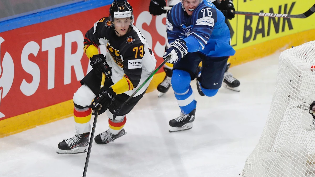 Finland's Jere Sallinen, right, challenges for the puck with Germany's Lukas Reichel during the Ice Hockey World Championship semifinal match between Finland and Germany at the Arena in Riga, Latvia, Saturday, June 5, 2021. (AP Photo/Sergei Grits)