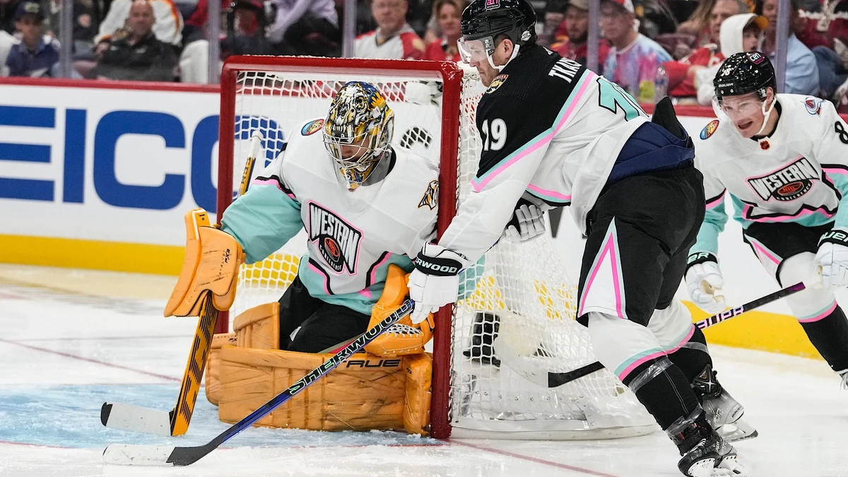 Atlantic Division's Matthew Tkachuk, of the Florida Panthers (19) works against Central Division's goaltender Juuse Saros, of the Nashville Predators (74) during the NHL All Star hockey game, Saturday, Feb. 4, 2023, in Sunrise, Fla. (AP Photo/Lynne Sladky)