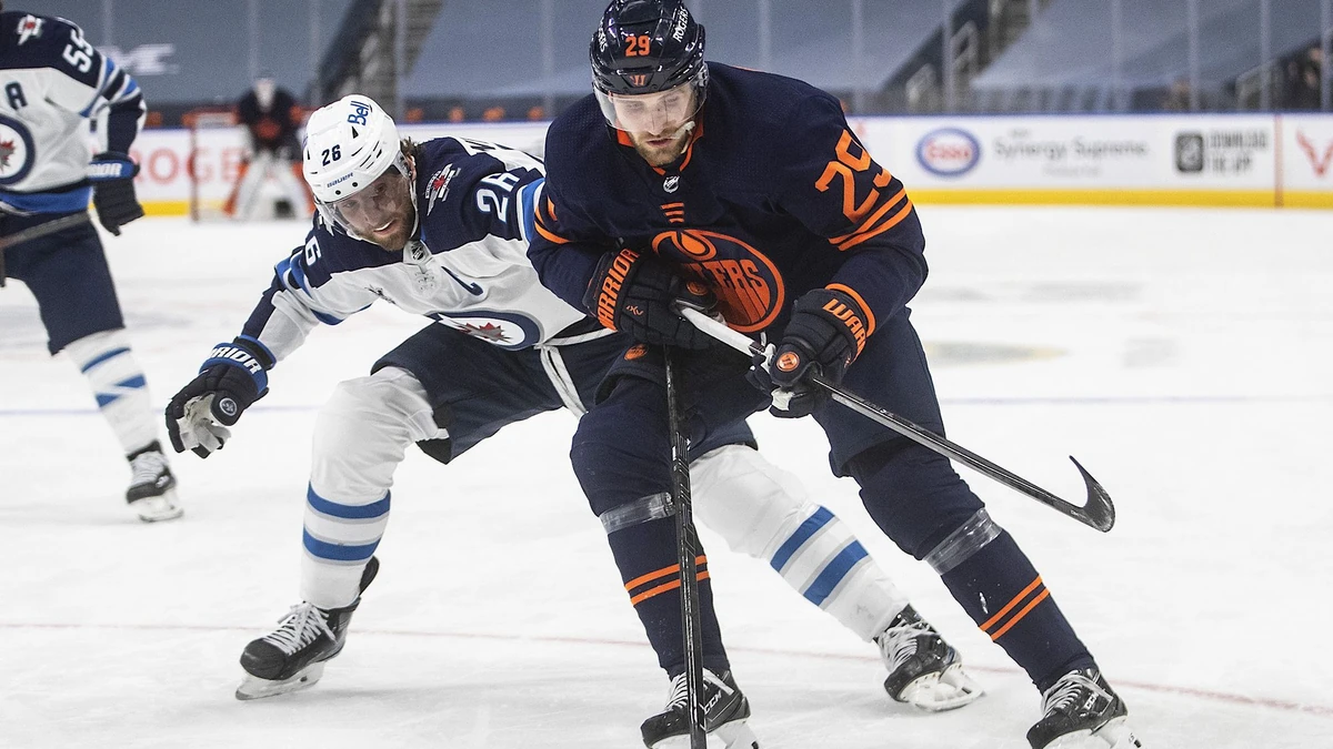 THE CANADIAN PRESS 2021-05-21. Edmonton Oilers' Leon Draisaitl (29) battles for the puck with Winnipeg Jets' Blake Wheeler (26) during second period NHL Stanley Cup playoff action in Edmonton on Friday, May 21, 2021.THE CANADIAN PRESS/Jason Franson URN:59926202