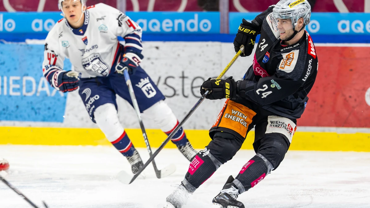 Eishockeyspieler Simon Bourque mit der Nummer 24 der Vienna Capitals im schwarzen Heimtrikot im Zweikampf gegen einen Spieler von Hydro Fehérvár AV19 in der STEFFL Arena Wien.