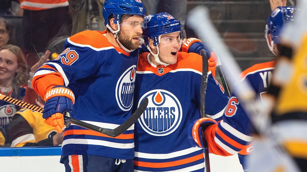 Edmonton Oilers' Leon Draisaitl (29) and Tyson Barrie (22) celebrate a goal against the Pittsburgh Penguins during second-period NHL hockey game action in Edmonton, Alberta, Monday, Oct. 24, 2022. (Jason Franson/The Canadian Press via AP)