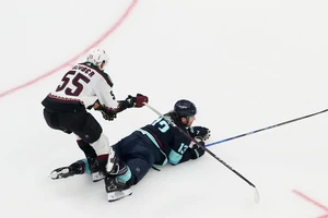 Seattle Kraken left wing Brandon Tanev (13) collides with Arizona Coyotes defenseman Maksymilian Szuber (55) as goaltender Karel Vejmelka (70) looks on near the goal during the first period of an NHL hockey game Tuesday, April 9, 2024, in Seattle. (AP Photo/Lindsey Wasson)