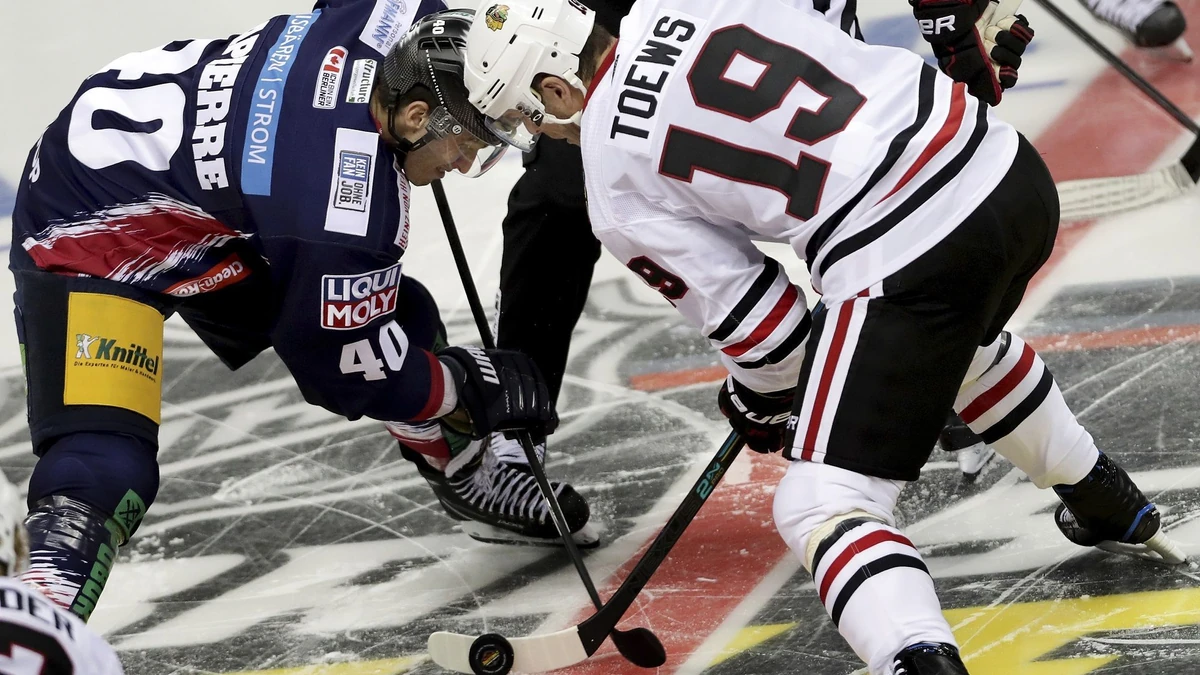 Berlins Maxim Lapierre (l.) beim Bully gegen Blackhawks-Kapitän Jonathan Toews